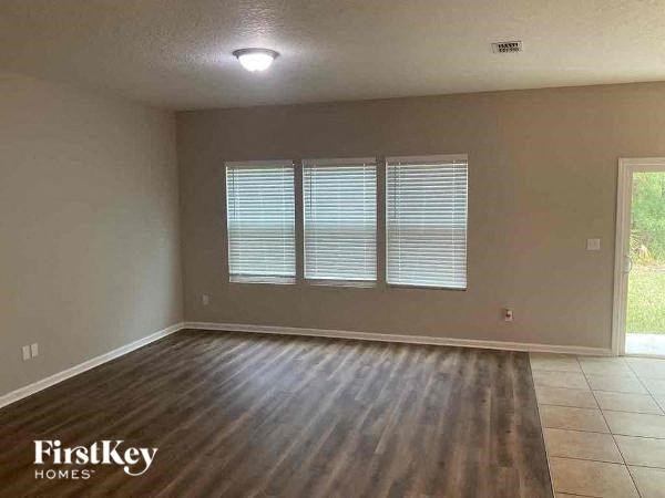 an empty living room with wooden floors and a window