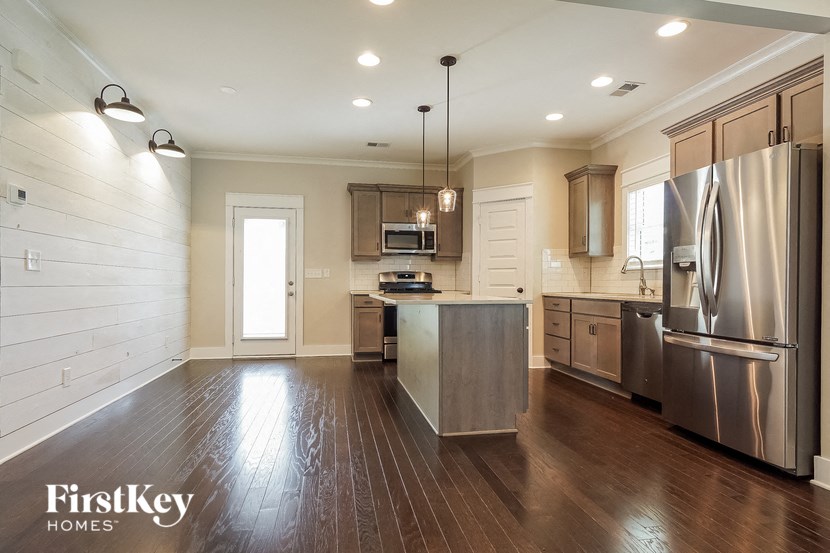 a kitchen with stainless steel appliances and wooden floors