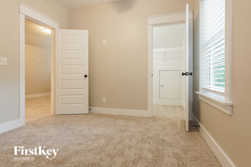 a bedroom with an open door and a carpeted floor