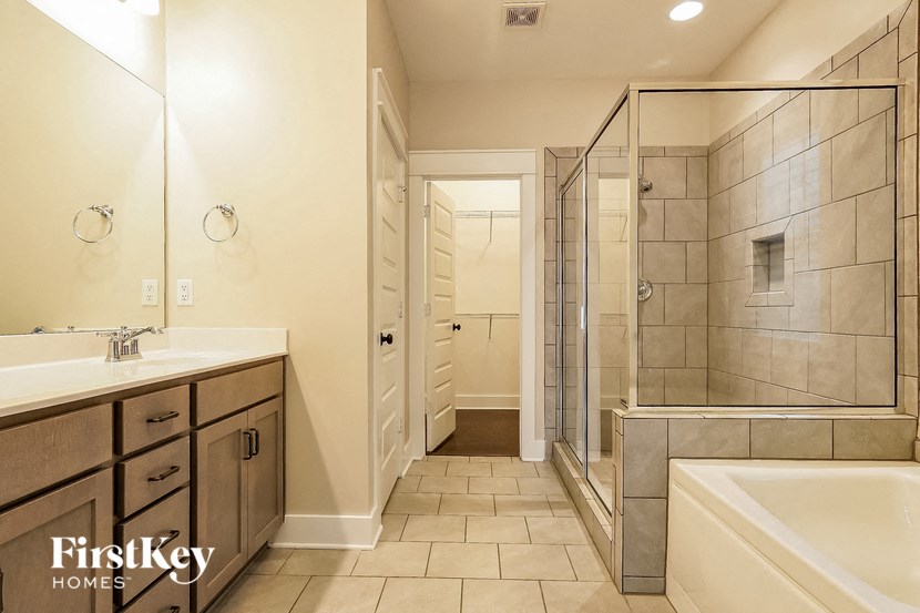 a bathroom with a tub and a shower and a sink