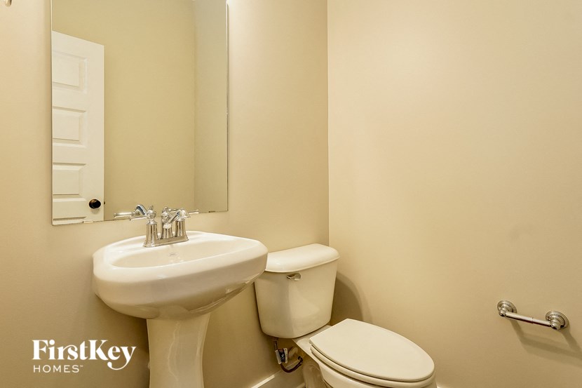 a bathroom with a sink toilet and a mirror