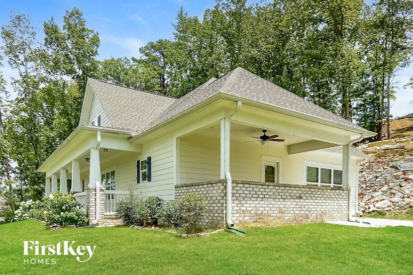 a white house with a porch and a green lawn