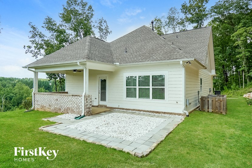 a small white house with a yard and a patio
