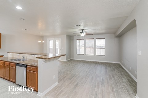 A spacious kitchen with wooden cabinets and a marble countertop.