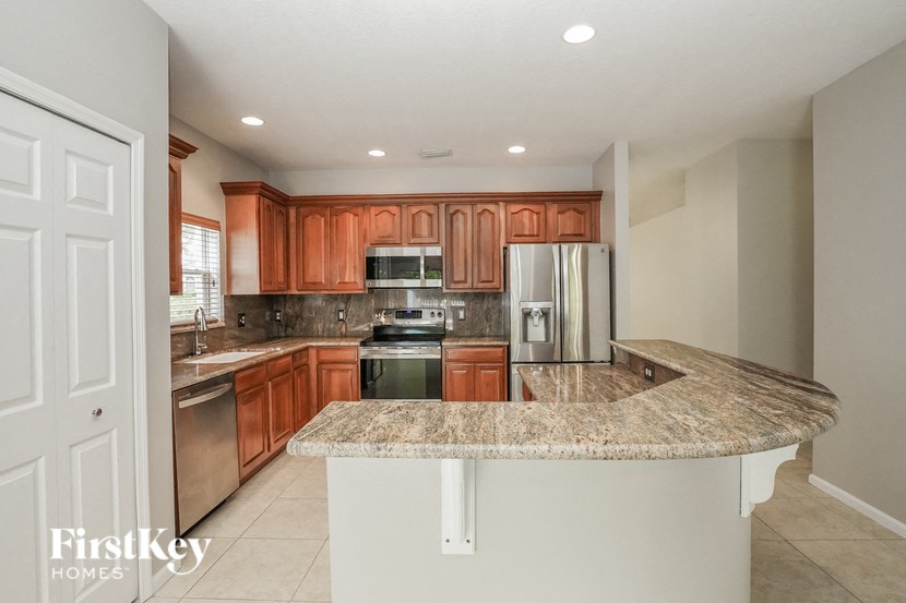 the kitchen has granite counter tops and wooden cabinets and stainless steel appliances