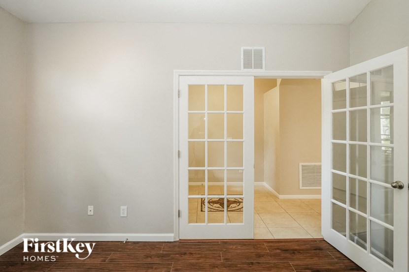 an empty room doors and a door to a closet