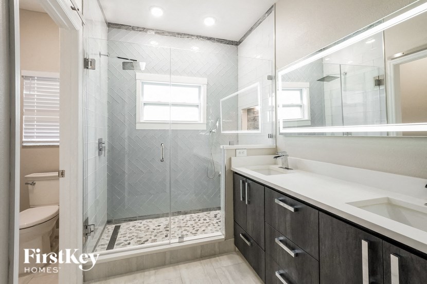 a bathroom with a shower and a sink and a mirror