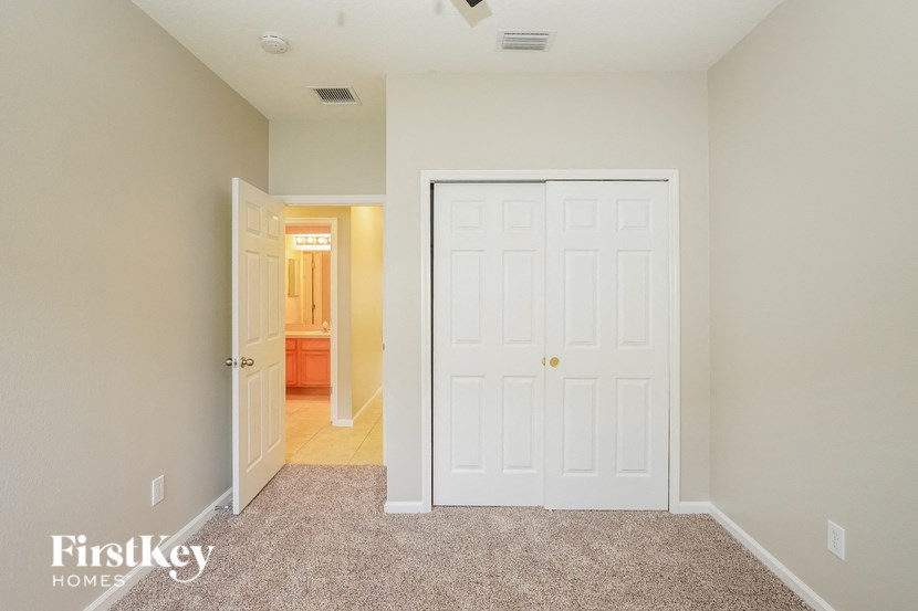 a bedroom with a closet and a door to a bathroom