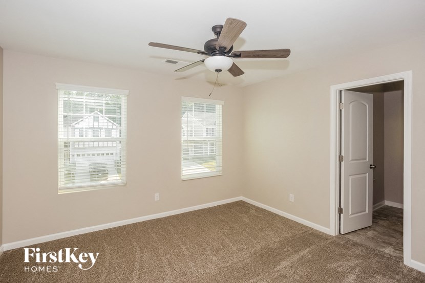 a bedroom with a ceiling fan and a door