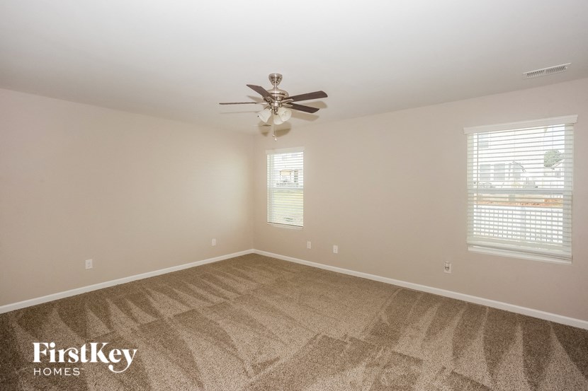 a bedroom with carpet and a ceiling fan