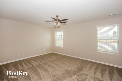 a bedroom with carpet and a ceiling fan