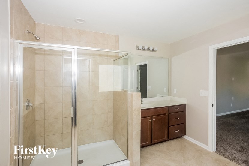 a bathroom with a shower and a sink and a mirror