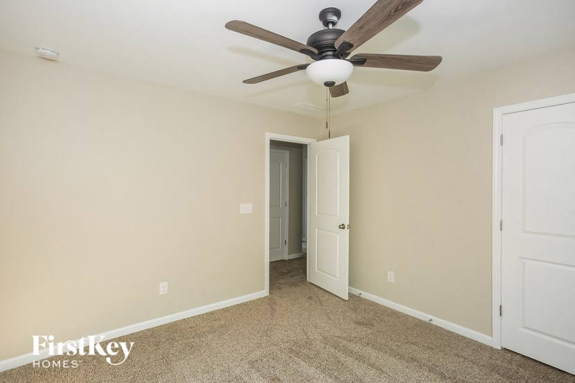 a bedroom with a ceiling fan and a door to a closet