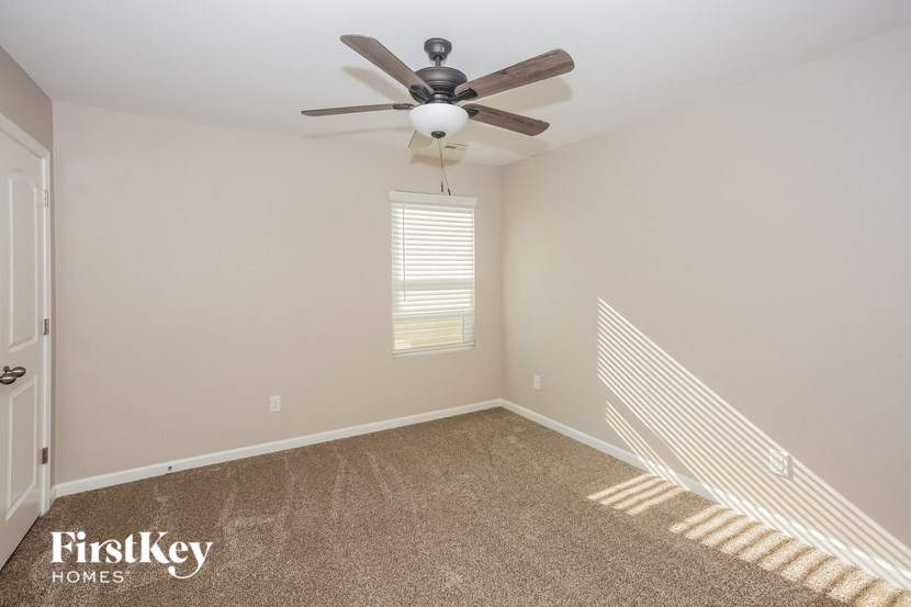 a bedroom with a ceiling fan and a window