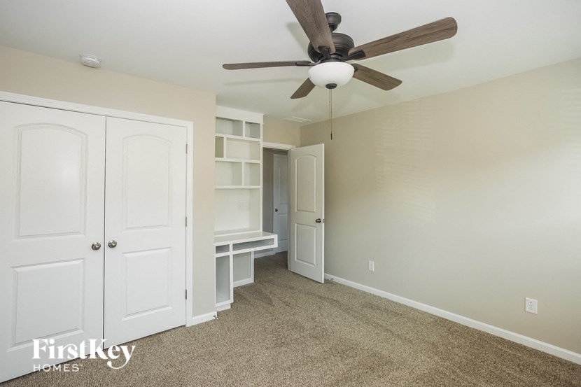 a bedroom with a ceiling fan and a closet