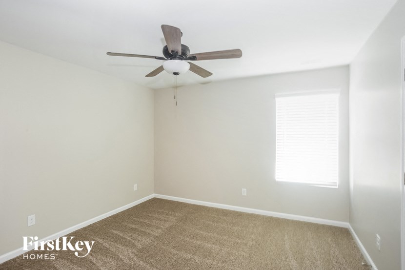 a room with a ceiling fan and a carpet