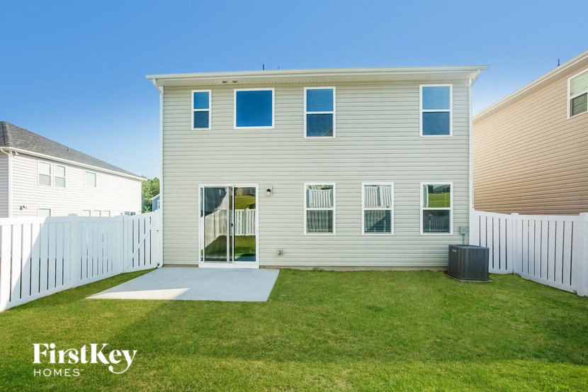 a white house with a grass yard and a white fence