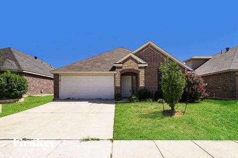 a small brick house with a white garage door