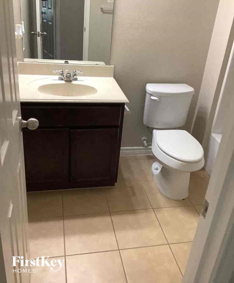 a bathroom with a sink toilet and a mirror