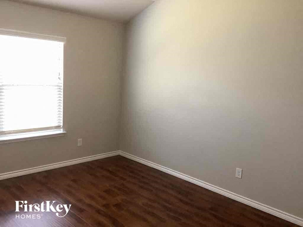 an empty room with wooden floors and a window