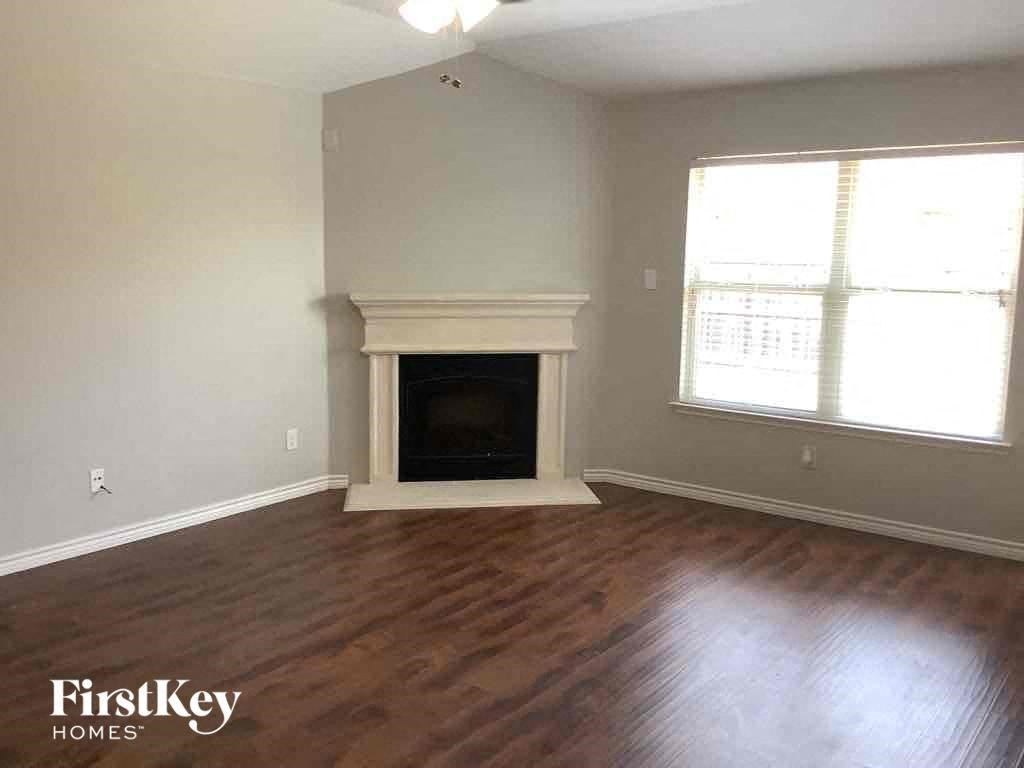 a living room with a fireplace and wooden floors
