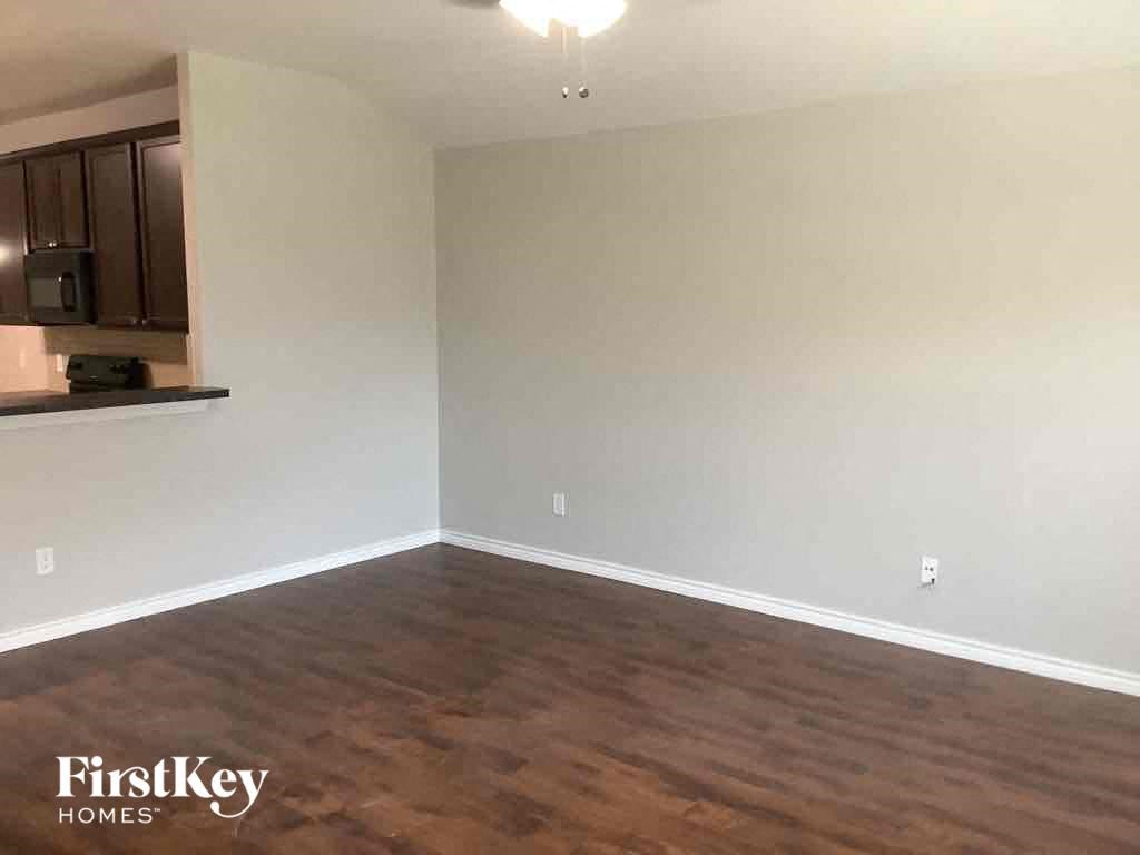 an empty living room with white walls and wood floors