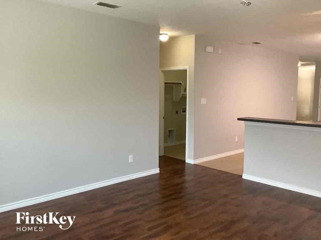 an empty living room with white walls and wood floors