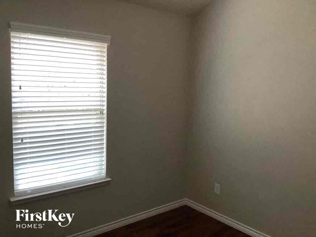 a small room with a window and a wooden floor