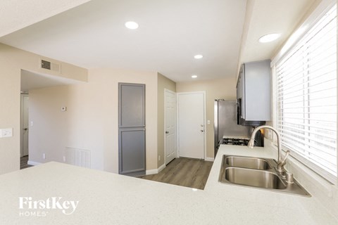 A kitchen with a sink and a refrigerator.