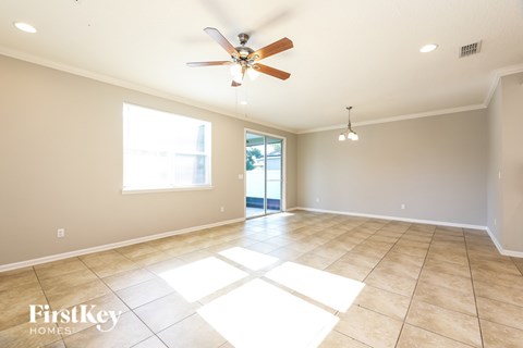 A spacious room with a ceiling fan and large windows.