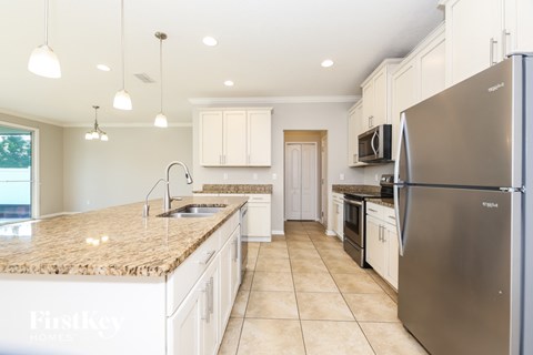 A kitchen with a granite countertop and stainless steel appliances.