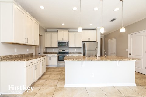 A kitchen with white cabinets and appliances.