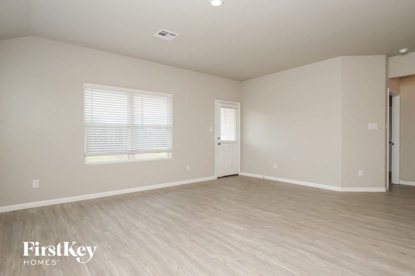 an empty living room with a door and a window