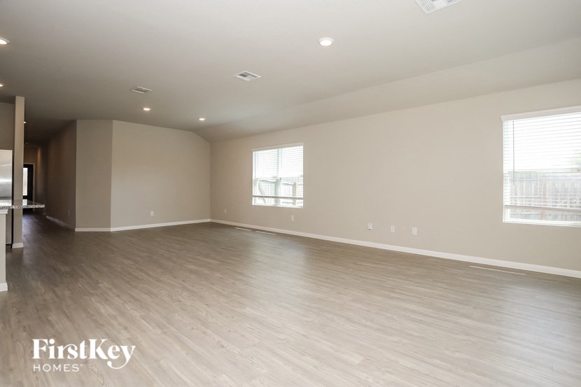 an empty living room with wood floors and white walls
