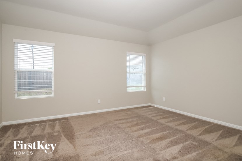 a bedroom with a carpeted floor and two windows