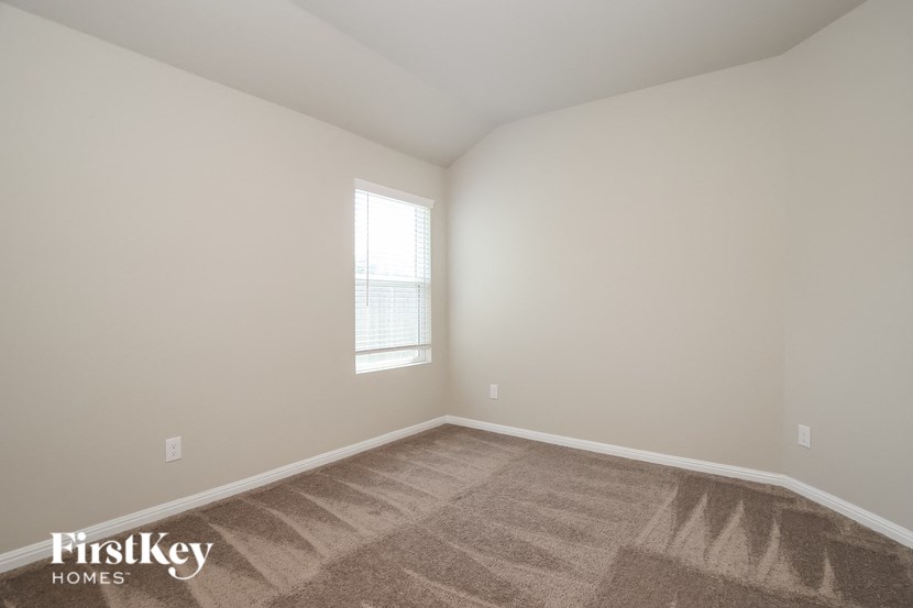 the living room of a home with carpet and a window