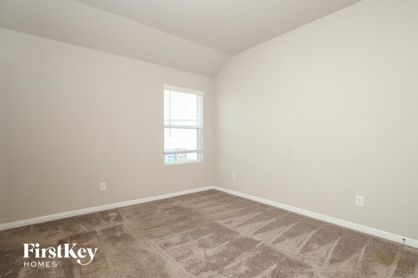 the living room of a home with carpet and a window