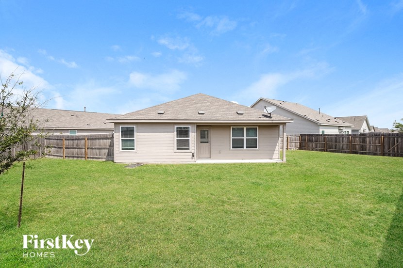 the backyard of a house with a lawn and a fence