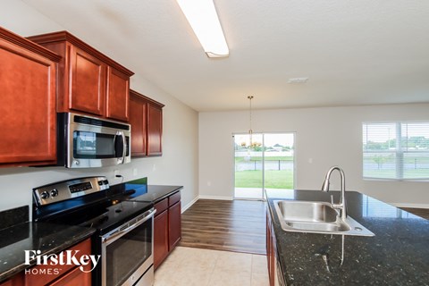 a kitchen with black granite counter tops and wooden cabinets