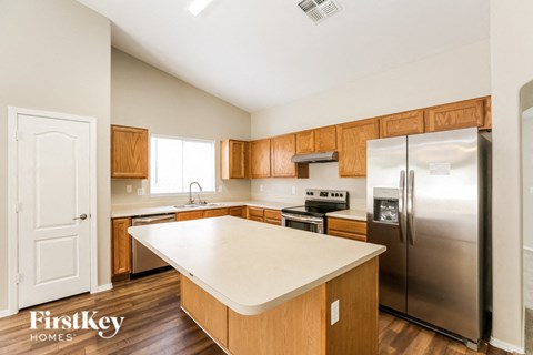 A kitchen with wooden cabinets and a stainless steel refrigerator.