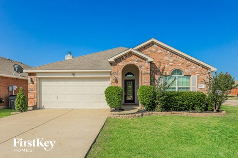 A brick house with a garage door and a black door.