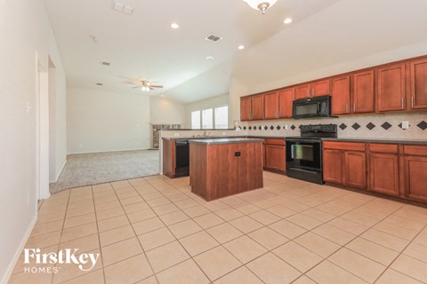 A kitchen with wooden cabinets and a black stove top oven.