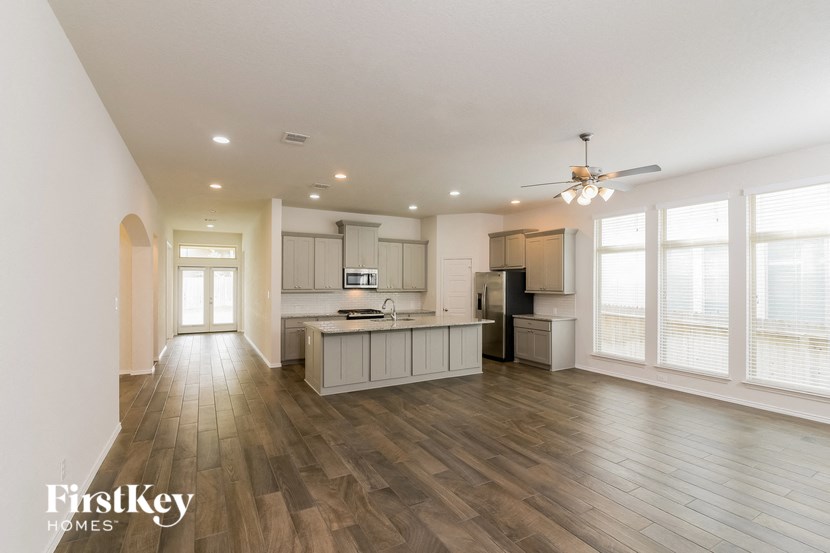 a kitchen and living room with wood flooring and a large window