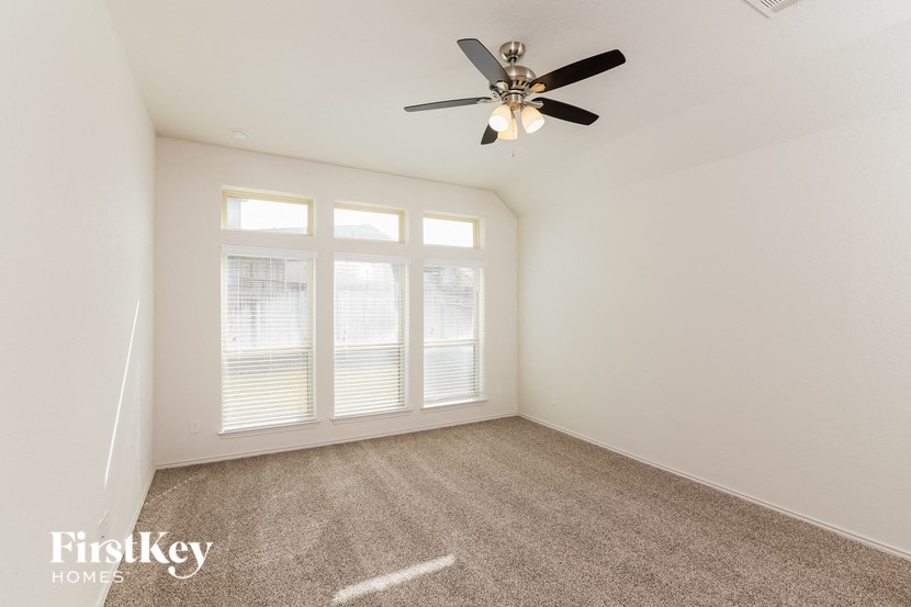 a living room with carpet and a ceiling fan