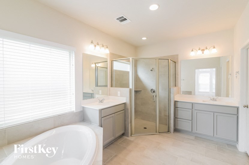 a bathroom with a tub and a shower and a sink