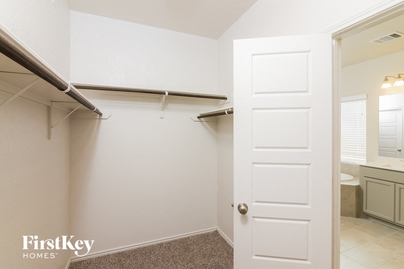 a closet with a white door and a bathroom with a toilet and a sink