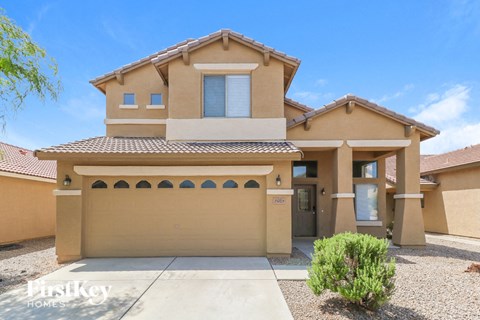 a tan house with a garage and a driveway