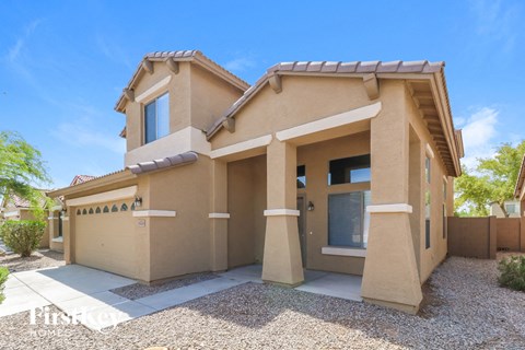 a beige house with a driveway in front of it