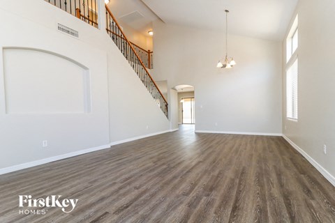 an empty living room with white walls and wood flooring