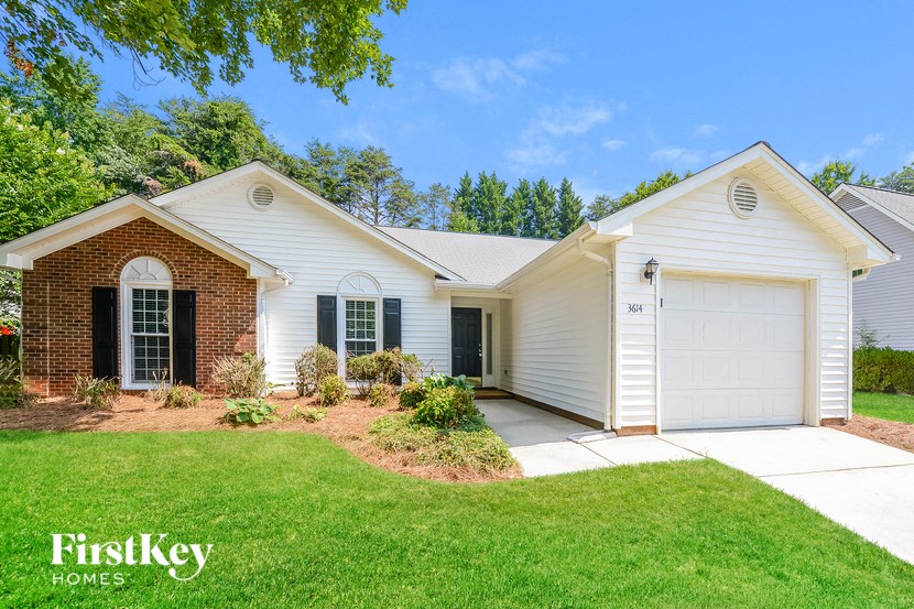 a white house with a white garage door and a lawn